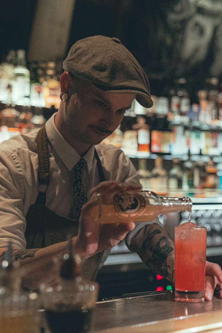 bartender pouring a highball at the counter